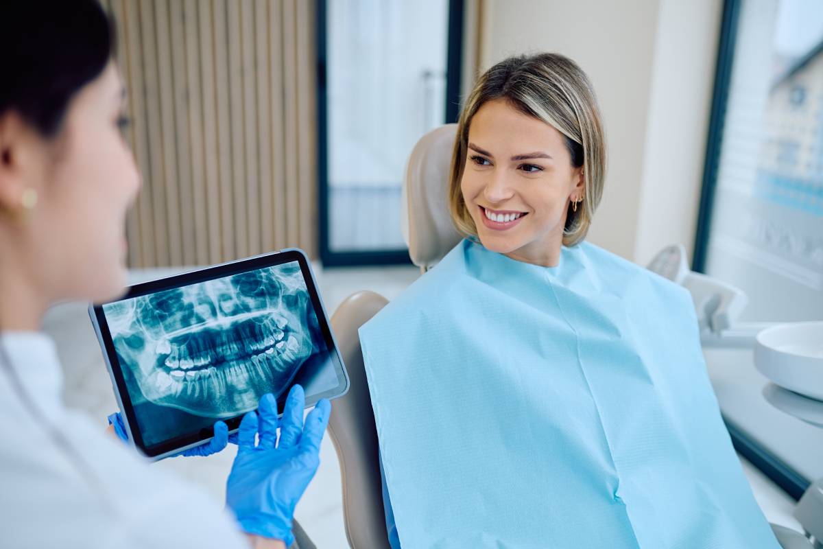 Dentist explaining dental x-ray to smiling patient
