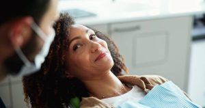 Patient smiling in dental chair after treatment.